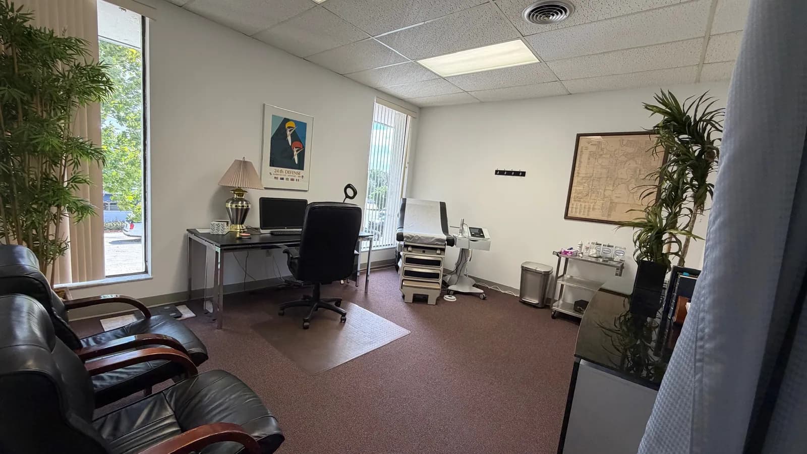 A room at the Maitland office with a desk, chairs and an exam table