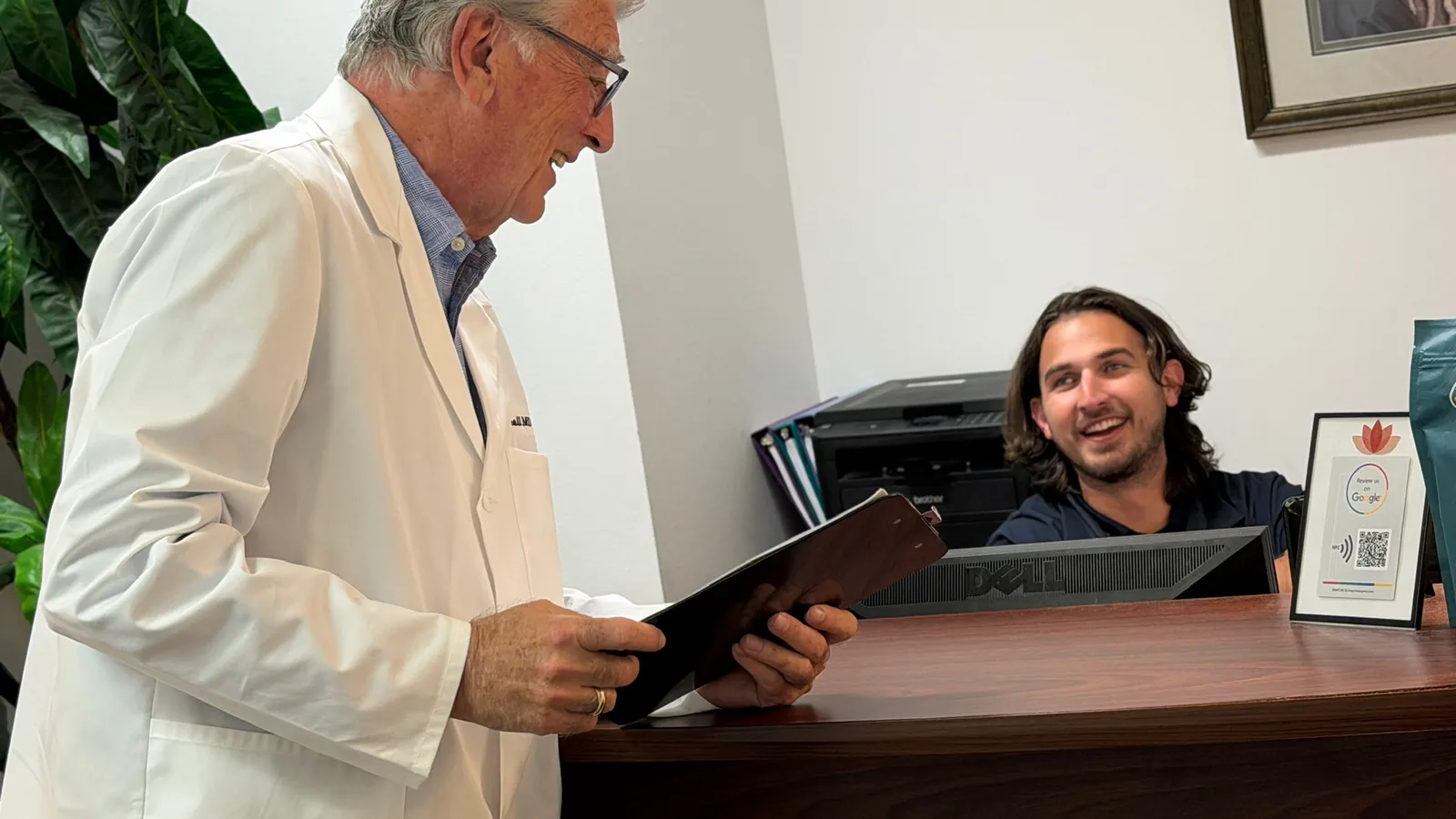 Dr. Carroll standing at the front desk of the Maitland office, talking with the receptionist